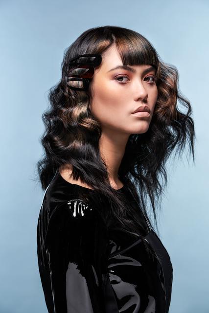 New Waves. Der glatte Pony erzeugt einen tollen Kontrast zu den gecurlten Längen. Die aufgebrochene Wellenstruktur lässt die Trendfrisur weicher und femininer wirken und sorgt für romantische Vibes. Ausgefallener Haarschmuck wie Clips sind das It-Piece der Saison schlechthin und verleihen noch mehr Glamour.
  | Foto: © ZV Friseurhandwerk