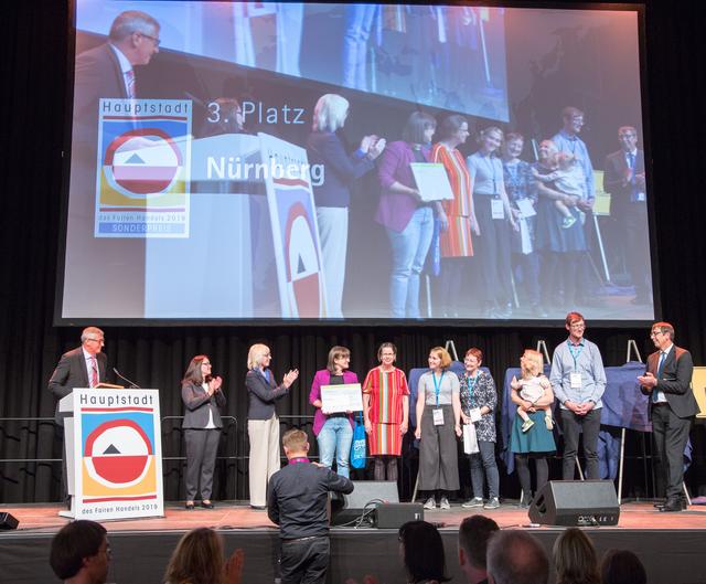 Preisverleihung ,,Hauptstadt des Fairen Handels 2019" am im Kölner E-Werk. Die Stadträte Christine Kayser (5. v.l.), Britta Walthelm (4. v.l.), Anna Baatz (5. v.r.) von der Nachhaltigkeits-Initiative Sneep, sowie Kerstin Stübs (3. v.r.) und Hiltrud Gödelmann (4. v.r.) vom Umweltreferat der nahmen den 3. Preis für die Stadt Nürnberg entgegen. | Foto: Jörg Loeffke / Engagement Global