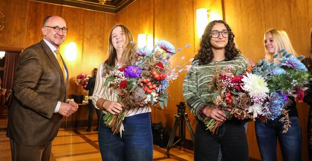 Der Pressesprecher der Stadt Dr. Siegfried Zelnhefer übergibt Blumen an Rebecca Ammon und Benigna Munsi (r.).  | Foto: Nicole Fuchsbauer