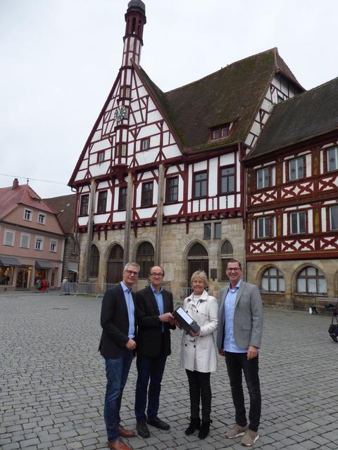 Für die Generalsanierung des Historischen Rathauses Forchheim wurde nun offiziell vom Stadtbauamt (Projektleiterin Claudia Stumpf mit dem Leiter des Bauordnungsamtes Stefan Schelter, 2.v.li.) die Baugenehmigung an Oberbürgermeister Dr. Uwe Kirschstein (links) auf dem Rathausplatz Forchheim übergeben. Dies ist der Startschuss für die umfangreiche Sanierung dieses Einzeldenkmals mit nationaler Bedeutung! Als neues Architekturbüro hat die Stadt Forchheim das Regensburger Architekturbüro fabi architekten bda PartGmbB, vertreten durch Stephan Fabi und Peter Krackler, gewonnen. | Foto: Britta Kurth, Stadt Forchheim