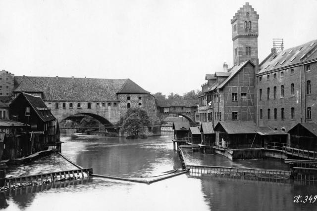 Die Nägeleinsmühlen um die Jahrhundertwende. Dahinter überspannt der Kettensteg unterhalb des Westtorzwingers die Pegnitz.