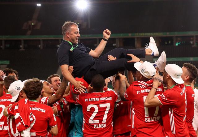 Münchens Trainer Hansi Flick wird von seinen Spielern in die Luft geworfen.  | Foto: Alexander Hassenstein/Getty Images Europe/Pool/dpa 