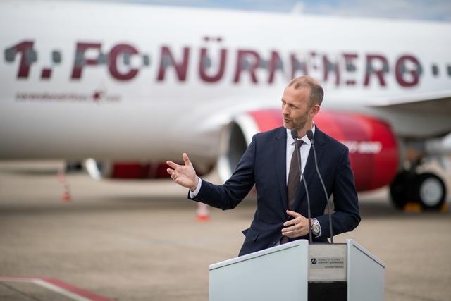 Niels Rossow, Kaufmännischer Vorstand des 1. FC Nürnberg, spricht zur Einweihung einer Linienmaschine der Fluggesellschaft Corendon im Design des Fußball-Zweitligisten 1. FC Nürnberg auf dem Vorfeld des Flughafens Nürnberg.  | Foto: Daniel Karmann/dpa