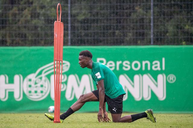 Der Spieler Dickson Abiama dehnt sich auf dem Platz.  | Foto: Daniel Karmann/dpa