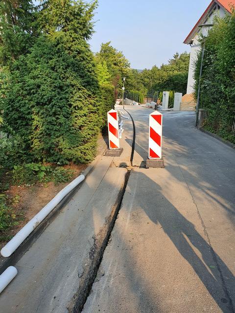 Der Straßenbelag des John-F.-Kennedy-Ringes wird für die Aufnahme des Glasfaserkabels vorbereitet.