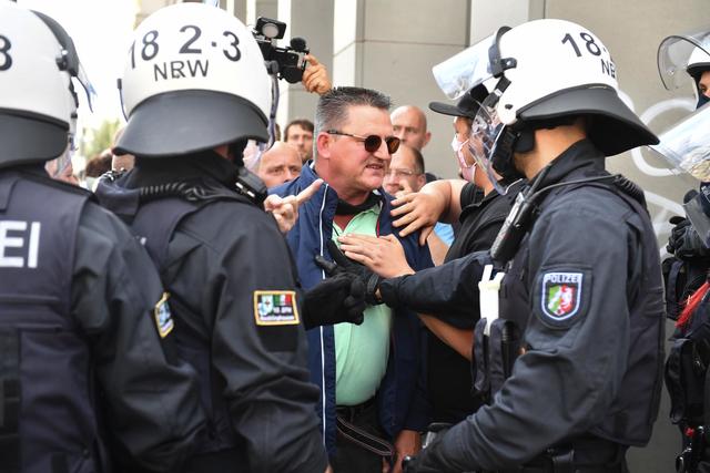 Die Polizei spricht mit einem Teilnehmer bei einer Demonstration gegen die Corona-Maßnahmen.  | Foto: Bernd Von Jutrczenka/dpa