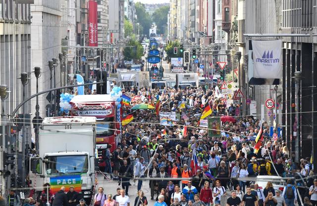 Menschen gehen bei einer Demo gegen Corona-Politik über die Friedrichstraße.  | Foto: Paul Zinken/dpa