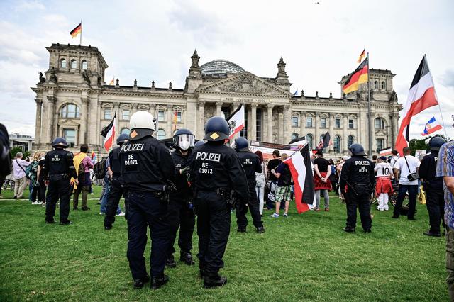  Demonstranten gegen die staatliche Corona-Politik haben am Samstagabend eine Absperrung am Reichstagsgebäude in Berlin durchbrochen. Sie seien die Treppe hoch gestürmt, berichtete ein dpa-Reporter am Ort. Polizeibeamte drängten die Menschen zurück, sie setzten Pfefferspray ein. Es kam zu Rangeleien. Am Reichstagsgebäude hatte es zuvor eine Kundgebung gegeben. | Foto: Fabian Sommer/dpa