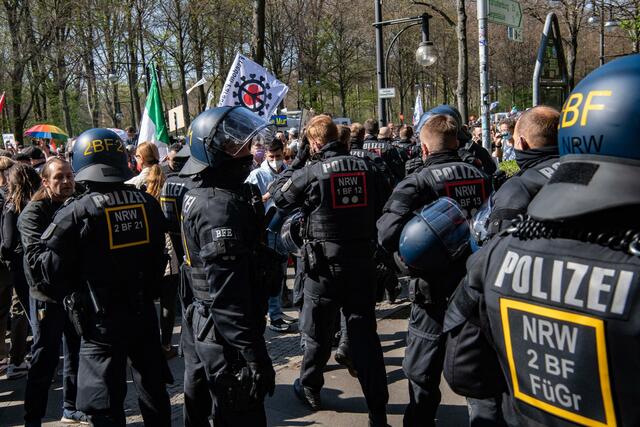 Einsatzkräfte der Polizei stehen auf der Straße des 17. Juni.