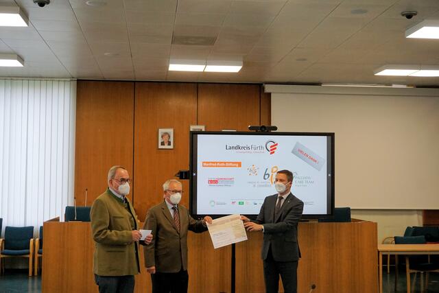 Dr. Polster und Klaus Teichmann von der Manfred Roth Stiftung übergeben 10.000 € an den Landrat für das Projekt BIG. | Foto: Landratsamt Fürth