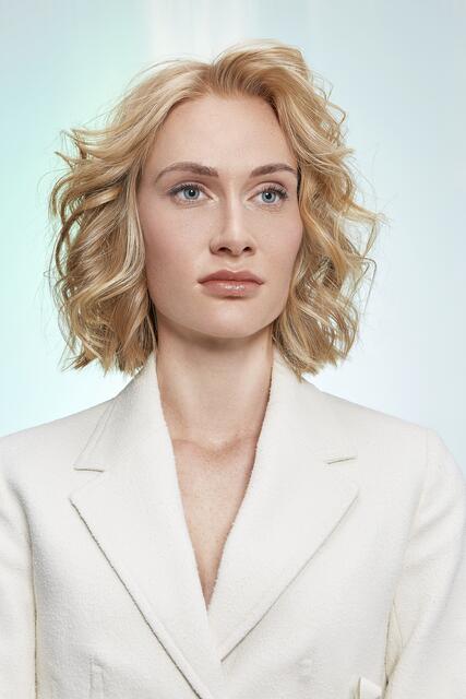 Mit luftig leichten Wellen bekommt der straighte
Blunt Cut ein Glamour-Update. Dafür mit dem
Lockenstab erst sanfte Wellen formen und dann
mit den Fingern lockern. Ein mattes Texturspray
bringt den gewünschten lived-in Look. Durch das
sanfte Face Framing in Sonnenblond und die
Stufung der Vorderpartie erhält der Look viel
Struktur und Tiefe. | Foto: ZENTRALVERBAND DES DEUTSCHEN FRISEURHANDWERKS