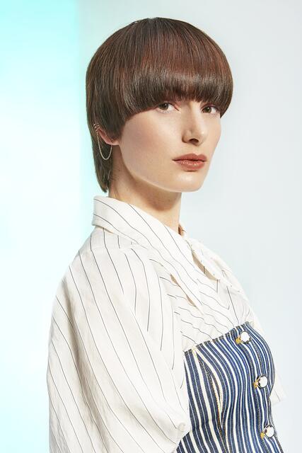 Der Bowl Cut erlebt 2021 ein ultimatives Level-up. Einen neuen Ausdruck erhält der Klassiker durch den längeren Nacken. Sehr feminin und lässig-elegant wirkt die glatte Version mit einem Long Pony, der bis über die Augenbrauen reicht. Für einen spannenden Effekt sorgt die kupferne Shine-Line im Vorderkopfbereich. Perfekt also für alle, die sich eine radikale Veränderung wünschen. | Foto: ZENTRALVERBAND DES DEUTSCHEN FRISEURHANDWERKS