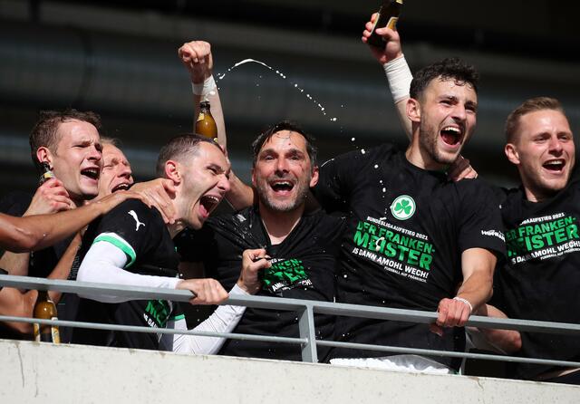 Die Aufstiegs-Helden um Chefcoach Stefan Leitl (Mitte) im ungezügelten Glücksrausch. | Foto: Daniel Karmann/dpa