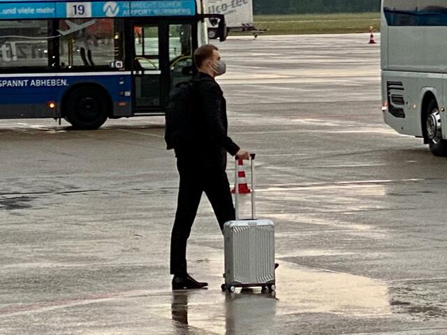 Mit seinem Rollkoffer macht sich Neuer auf den Weg zu den zwei bereitstehenden Mannschaftsbussen. | Foto: Peter Maskow