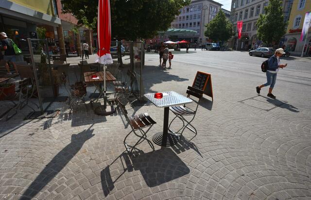 Stühle und Tische eines Biergartens nahe des Tatorts in der Innenstadt.  | Foto: Karl-Josef Hildenbrand/dpa