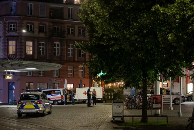 Einsatzfahrzeuge stehen nahe des Tatorts auf dem Barbarossaplatz.  | Foto: Daniel Karmann/dpa