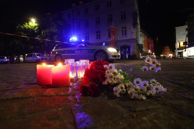 Kerzen und Blumen liegen nahe des Tatorts in der Innenstadt.  | Foto: Karl-Josef Hildenbrand/dpa