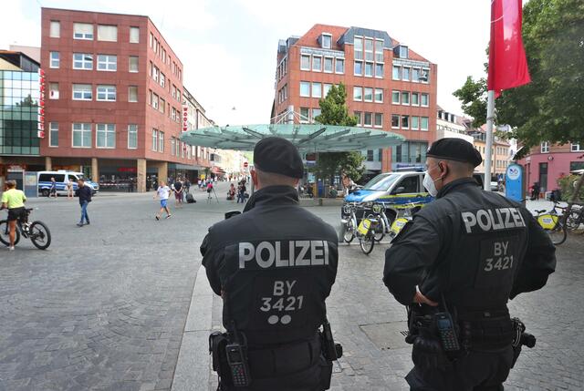 Polizisten stehen am Tatort in der Innenstadt.  | Foto: Karl-Josef Hildenbrand/dpa