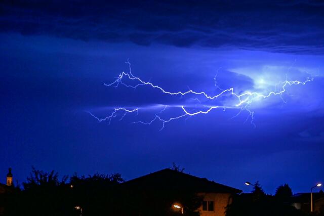 Blitze entladen sich am Nachthimmel.
