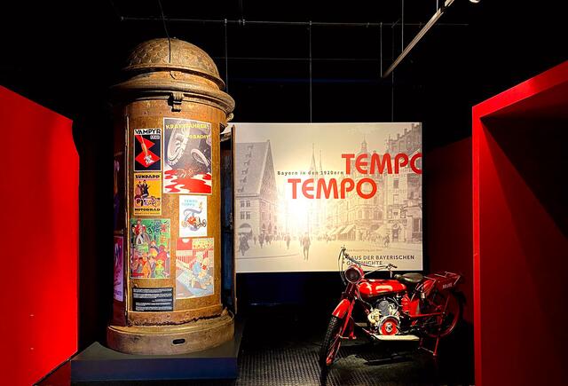Blick in den Vorraum der Ausstellung mit einer Nürnberger Litfaßsäule, hergestellt um 1905 bei MAN, und einer Ardie Minimax, Baujahr 1920. | Foto: Museen der Stadt Nürnberg, Museum Industriekultur