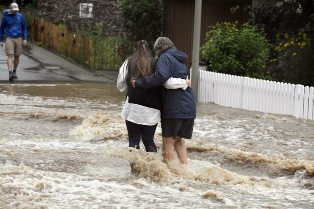 Anwohner der Ortschaft Balken helfen sich durch Fluten der Wupper. 
 | Foto: Roberto Pfeil/dpa