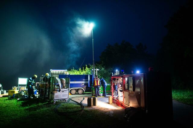 Mitarbeiter des Technischen Hilfswerks pumpen an der Steinbachtalsperre Wasser über die Staumauer.  | Foto: Jonas Güttler/dpa