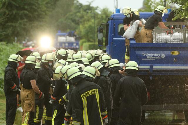Die Feuerwehr versucht, die Wassermassen mit Sandsäcke zu stoppen. 
 | Foto: David Young/dpa