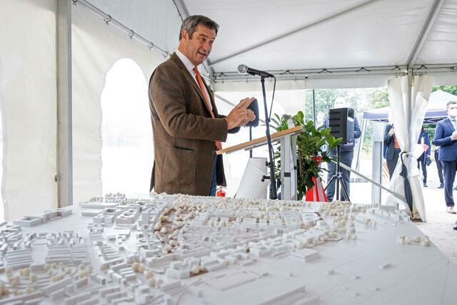 Markus Söder spricht während dem symbolischen Spatenstich für den Bau der neuen TU Nürnberg neben einem Architekturmodell.  | Foto: Daniel Karmann/dpa