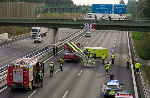 Aktivisten nehmen an einer Banneraktion an einer Brücke über der Autobahn A96 teil.  | Foto: Peter Kneffel/dpa