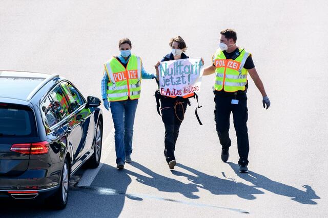 Polizisten nehmen auf der A9 eine Aktivistin fest.