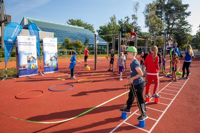 Bayerns Innenminister Joachim Herrmann stellte auf dem Sportgelände des Post SV Nürnberg gemeinsam mit dem Präsidenten des Bayerischen Landessportverbandes, Jörg Ammon, dem 1. Landesschützenmeister des Bayerischen Sportschützenbundes, Christian Kühn, dem Präsidenten des Oberpfälzer Schützenbundes, Franz Brunner, und der Vizepräsidentin des Behinderten- und Rehabilitations-Sportverbands Bayern, Ria Engelhardt, das neue Gutscheinprogramm vor. Herrmann übergab dabei einen symbolischen Gutschein an eine Gruppe von Kindern.  | Foto: Norbert Wilhelmi/stmi