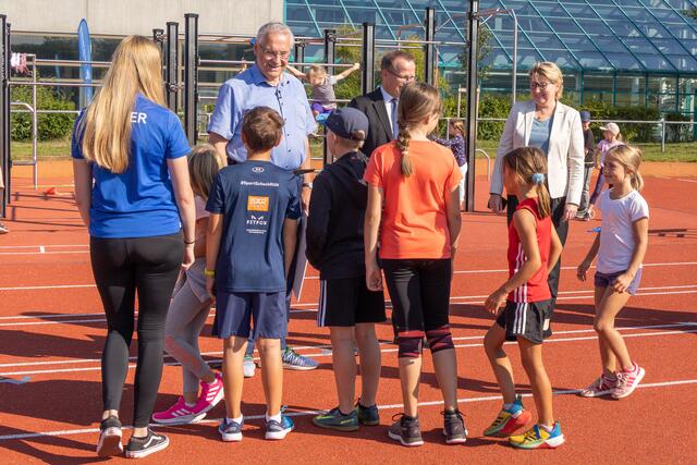 Bayerns Innenminister Joachim Herrmann  stellte auf dem Sportgelände des Post SV Nürnberg gemeinsam mit dem Präsidenten des Bayerischen Landessportverbandes, Jörg Ammon, dem 1. Landesschützenmeister des Bayerischen Sportschützenbundes, Christian Kühn, dem Präsidenten des Oberpfälzer Schützenbundes, Franz Brunner, und der Vizepräsidentin des Behinderten- und Rehabilitations-Sportverbands Bayern, Ria Engelhardt, das neue Gutscheinprogramm vor. Herrmann übergab dabei einen symbolischen Gutschein an eine Gruppe von Kindern.  | Foto: Norbert Wilhelmi/stmi