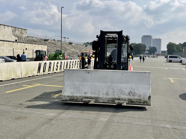 Per Stapler rollt ein bis zu sechs Tonnen schweres Teil der Betonleitplanke heran. Im Hintergrund die Grundigtürme. | Foto: Peter Maskow