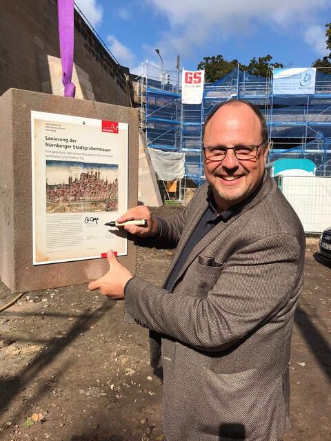 Bürgermeister Christian Vogel signierte eine Nachricht für zukünftige Generationen: Danach wurde die Platte mit Inschrift in das Mauerwerk eingelassen und der letzte Sandsteinblock aufgesetzt.  | Foto: Stadt Nürnberg