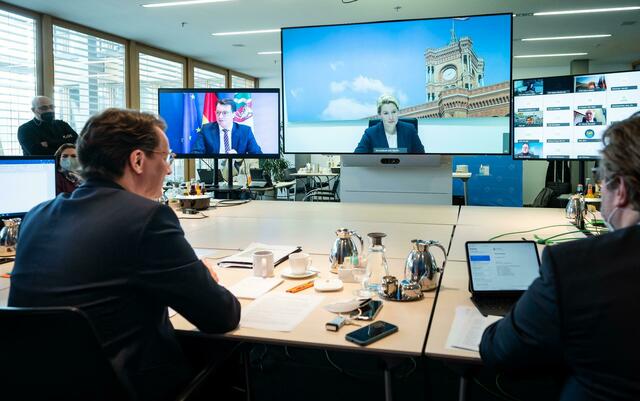 NRW-Ministerpräsident Hendrik Wüst (l.), während der Videokonferenz. Auf dem großen Bildschirm ist Berlins Regierende Bürgermeisterin Franziska zugeschaltet.