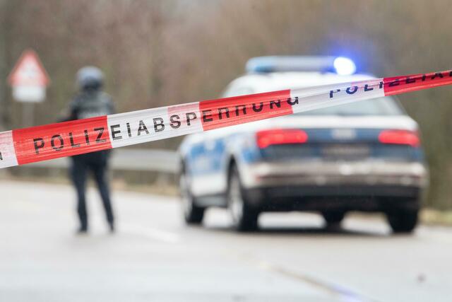 Schwerbewaffnete Polizisten stehen an einer Straßensperre.  | Foto: Sebastian Gollnow/dpa 