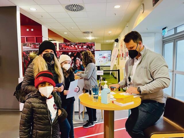 Zusammenhalt! Große und kleine Clubfans warten auf ihren Pieks gegen Omikron. | Foto: 1. FCN