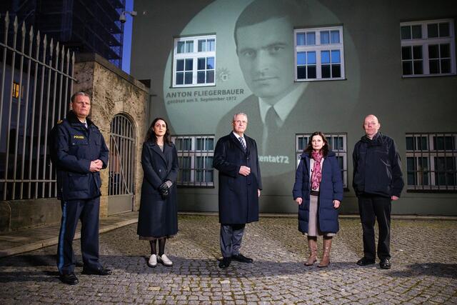 9. Februar 2022: Vor 50 Jahren starben zwölf Menschen bei den Olympischen Spielen in München – darunter auch Polizeiobermeister Anton Fliegerbauer. Mit einer Projektion von Fliegerbauer zusammen mit den Namen der elf weiteren Getöteten auf der Gebäudefassade vor dem Haupteingang des Polizeipräsidiums München wird an das Attentat vom 5./6. September 1972 erinnert. „Wir werden seinen heldenhaften Einsatz nie vergessen“, betonte Bayerns Innenminister Joachim Herrmann (Mitte) zum Start der Projektion.
 | Foto: Matthias Balk