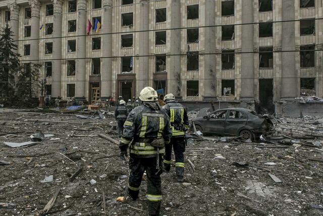 Ukrainische Rettungskräfte vor dem von Beschuss beschädigten Rathausgebäude in Charkiw.  | Foto: Pavel Dorogoy/AP/dpa