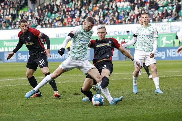 Der Freiburger Nico Schlotterbeck (2.v.r.) grätscht dem Fürther Branimir Hrgota (2.v.l.) im Strafraum den Ball vom Fuß, links der Freiburger Christian Günter. | Foto: Daniel Löb/dpa