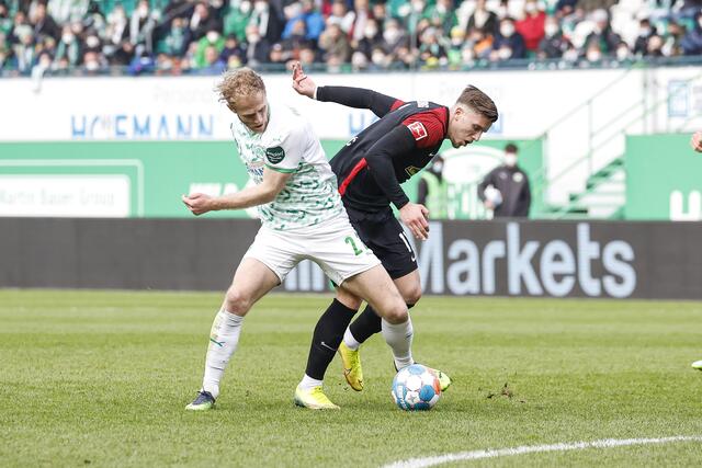 Der Fürther Sebastian Griesbeck (l) kommt vor dem Freiburger Ermedin Demirovic an den Ball.
 | Foto: Daniel Löb/dpa