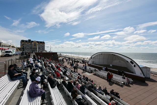 Besucher verweilen auf der Kurpromenade von Westerland vor der «Musikmuschel».  | Foto: Bodo Marks/dpa 
