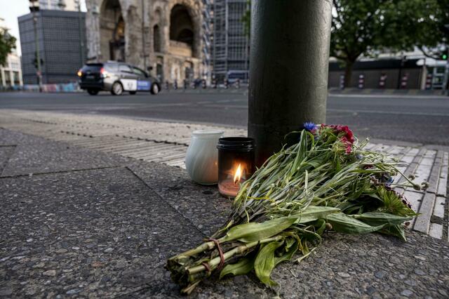 Kerzen und ein Blumenstrauß liegen zum Gedenken auf dem Bürgersteig an der Tauentzienstraße in Berlin.  | Foto: Fabian Sommer/dpa 