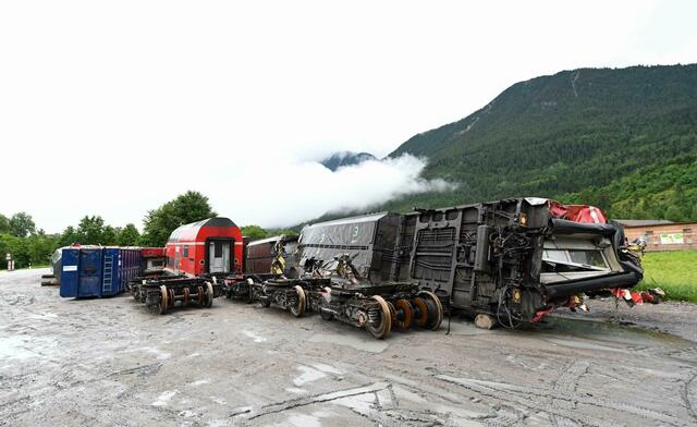 Die zerstörten Zugwagons und die Drehgestelle stehen in der Nähe der Unglücksstelle auf einem Betriebshof.  | Foto: Tobias Hase/dpa 