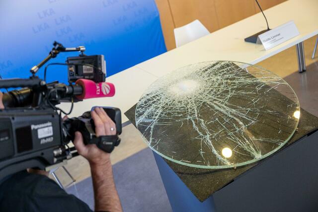 Eine eingeschlagene Vitrinenscheibe wurde vor Beginn einer Pressekonferenz der Polizei im Kelten-Römer-Museum gezeigt.  | Foto:  Peter Kneffel/dpa