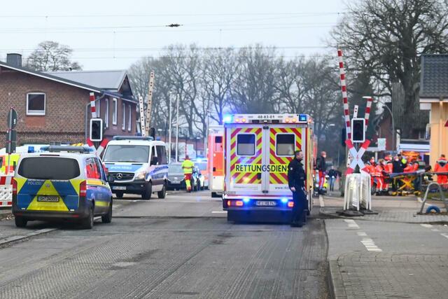 Einsatzkräfte der Polizei und Feuerwehr in der Nähe des Bahnhofes in Brokstedt in Schleswig-Holstein.  | Foto: Jonas Walzberg/dpa