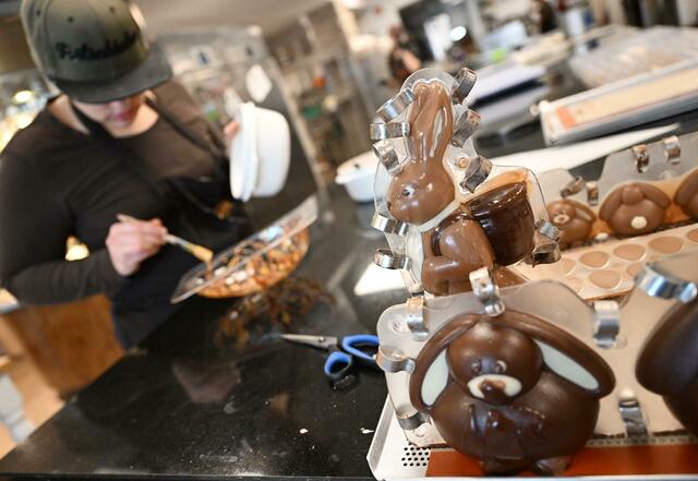 Eine Konditorin «schminkt» in der Chocolaterie Amelie in Garmisch-Partenkirchen eine Osterei-Form.  | Foto:  Angelika Warmuth/dpa