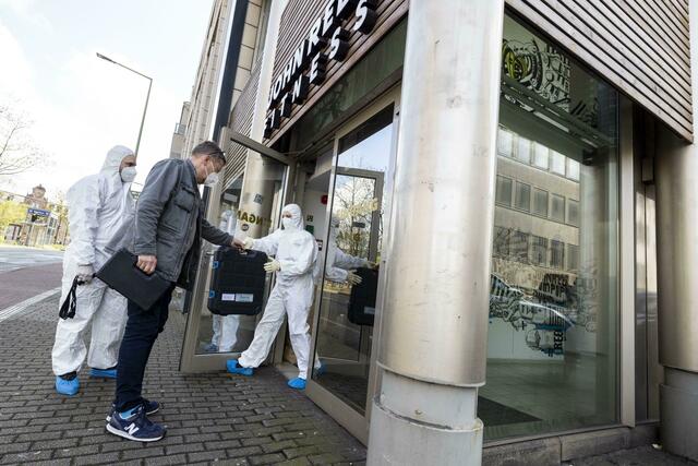 Ein Beamter in zivil bringt den vor Ort anwesenden Beamten der Spurensicherung technisches Equipment zum Tatort.  | Foto: Christoph Reichwein/dpa