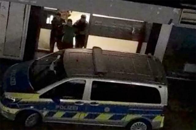 Ein Mann wird von der Polizei aus einem Haus in Duisburg geführt.  | Foto:  Christoph Reichwein/dpa