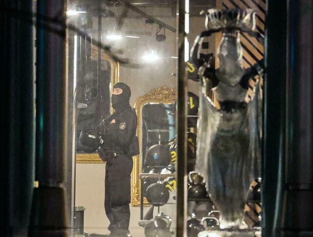 Ein Polizist ist nach der Attacke in dem Duisburger Fitnessstudio im Einsatz.  | Foto: Oliver Berg/dpa